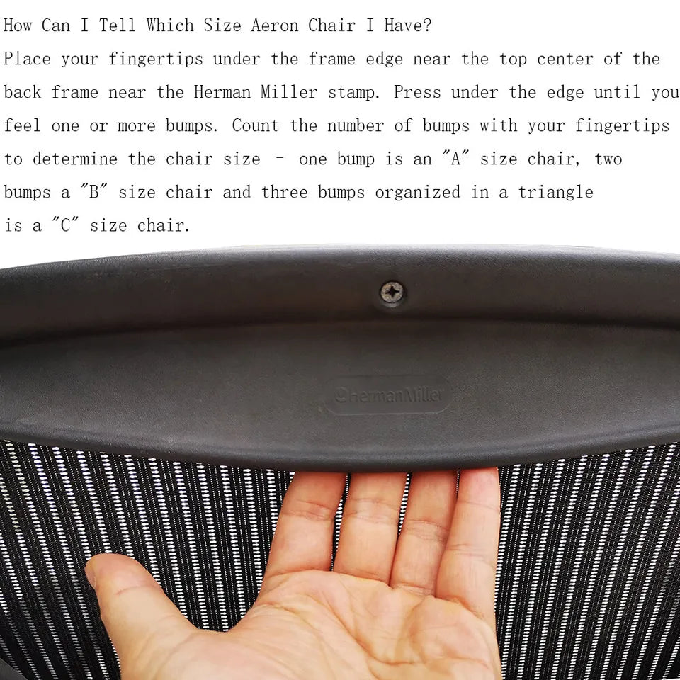 Fingertips under the top edge of an Aeron chair's back frame, feeling for the bumps that show its size